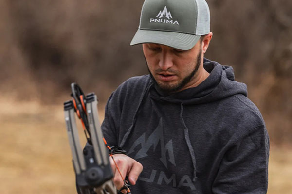 A piece of Pnuma Outdoors gear showing rugged fabric details and the brand's lifetime guarantee logo.