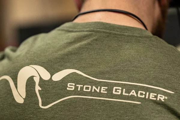 A hunter using a Stone Glacier load-hauling backpack in a rugged, remote wilderness setting.